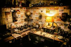 an old fashioned kitchen with lots of clutter on the counter and shelves above it