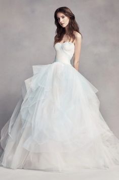 a woman in a white wedding dress posing for a photo with her hands on her hips