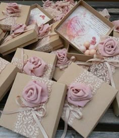 there are many small boxes with pink roses on them, and one box has a card in it