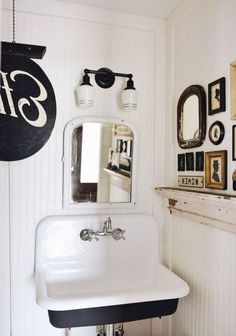 a bathroom with a sink, mirror and pictures on the wall