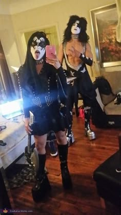 two people dressed up as kiss band members taking a selfie in their living room