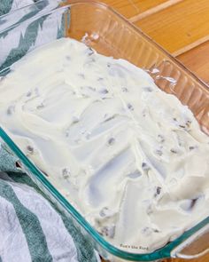 a glass casserole dish filled with white frosting and chocolate chips on top