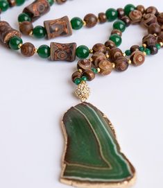 Tibetan agate, green agate, gold hematite and brass chain with large green agate slab. Bohemian style necklace is approximately 32". Looks great with the Freeform Green Recycled Brass Cuff, which is sold separately. Every item sold plants a tree through our partnership with One Tree Planted. Luxury Gold Agate Necklace, Luxury Statement Agate Jewelry, Bohemian Green Onyx Necklaces With Natural Stones, Bohemian Green Onyx Necklace With Natural Stones, Bohemian Green Onyx Gemstone Bead Necklaces, Bohemian Green Agate Necklaces, Bohemian Beaded Necklace With Green Onyx, Bohemian Green Onyx Beaded Necklace With Natural Stones, Unique Green Necklace With 108 Beads