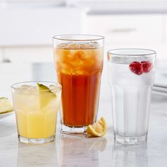 three glasses filled with different types of drinks