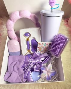 a box filled with purple items on top of a fur rug next to a cup