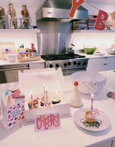 a birthday party with cupcakes and candles on the kitchen counter, in front of an oven