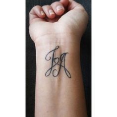 a woman's wrist tattoo with the letter j on her left hand and an initial in the middle