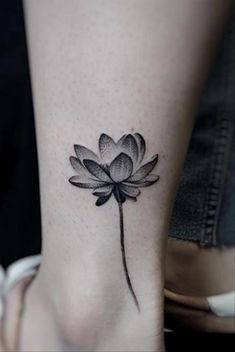 a black and white flower tattoo on the ankle