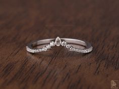 a close up of a wedding ring on a wooden table