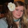 a woman with long hair and a flower in her hair is posing for the camera