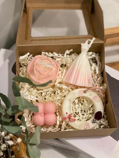 an open box with soaps and other items in it sitting on a table next to a potted plant