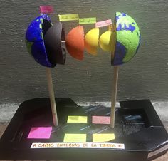 the earth is made out of sticky notes on sticks and placed in a black tray