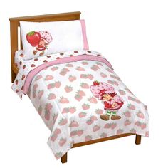 a child's bed with strawberry themed sheets and pillows