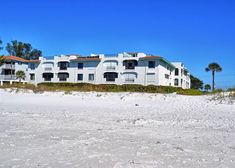 an apartment building on the beach with palm trees