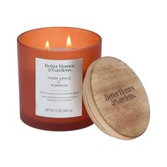 a candle that is next to a wooden container with a label on the front and side