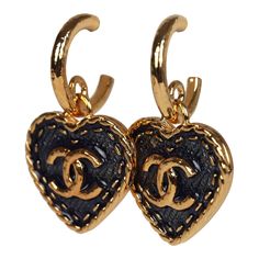 These Chanel CC denim heart earrings feature small gold tone metal CC hoops with a dangling gold and blue Denim enamel heart, with a gold tone CC in the center, and have post back earring closure. Origin: ItalyCondition: New and never wornAccompanied by: Box, felt jewelry cover, ribbon, carebook and retail UPC, Measurements: 1.5" (top of hoop to bottom of heart) x 1" (across heart) Yellow Gold Earrings With Heart Charm, Chanel Earrings Hoop, Chanel Heart Earrings, Gold Enamel Heart Charm Earrings, Chanel Logo Earrings, Gold Heart-shaped Enamel Earrings, Gold Enamel Heart-shaped Earrings, Vintage Chanel Earrings, Channel Earrings Pearl Vintage Chanel