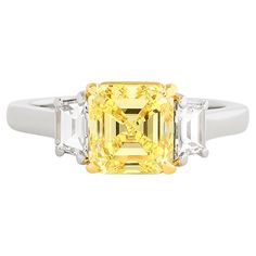 Golden Glow: Embrace the brilliance of this Cartier 3 stone diamond ring featuring a Fancy Intense Yellow square emerald cut diamond at its heart. Made in platinum and 18k yellow gold, this ring has: 1 square emerald cut that weighs ~2.01 carat and is a Fancy Intense Yellow with VS1 clarity; accompanied with a GIA certificate. 2 trapezoid diamonds that weigh ~0.60 total carat and are G-H color and VS clarity. Ring is stamped: "Cartier, PT950, 750, Cartier stock number" Ring size Yellow Emerald Cut Diamond Ring, Yellow Diamond Ring With Emerald Cut, Three Stone Square Cut Diamond Rings, Luxury Emerald Ring With Three Stones And Radiant Cut, Luxury Three Stone Radiant Cut Emerald Ring, Yellow Diamond Ring With Emerald Cut Center Stone, Luxury Radiant Cut Three Stone Emerald Ring, Radiant Cut Three Stone Emerald Ring For Anniversary, Three Stone Diamond Ring For Anniversary With Asscher Cut