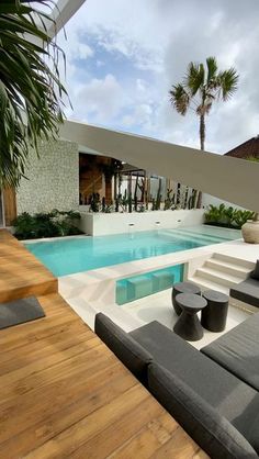 a modern house with a pool and lounge chairs