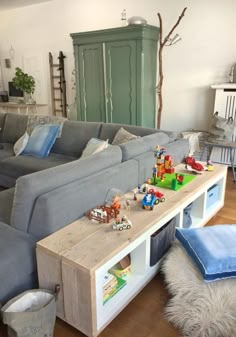 a living room filled with lots of furniture and toys on top of a wooden table