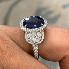 An enviable jewel, this ring sports some dazzling Diamonds & a sparkling Sapphire. Gemstones Type: Sapphire Gemstones Shape: Oval Gemstones Weight: 5.38 ct Gemstones Color: Blue Diamonds Shape: Round & Marquise Side Diamonds Weight: 2.13 ct Side Diamond Color: F - G Side Diamond Clarity: VS (Very Slightly Included) Metal: 18K White Gold Metal Wt: 7.7 gms Setting: Prong & Pave Set Finger Size: 7 To have the ring sized, please note the desired size in Special Instructions during checkout. Luxury Gia Certified Diamond Gemstones, Brilliant Cut Sapphire Diamond Gemstones, Gia-certified Cluster Sapphire Ring With Diamond, Gia Certified Cluster Sapphire Ring With Diamond, Luxury Gia Certified Diamond White Sapphire Ring, Dazzling Round Gemstones With Diamond Accents, Certified Oval Diamond Halo Ring, Gia Certified Oval Diamond Halo Ring, Dazzling Gemstones With Diamond Accents