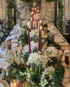 a long table is set with candles and flowers for an elegant christmas dinner or party