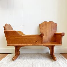 a wooden bench sitting on top of a carpeted floor next to a white wall