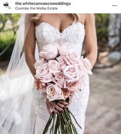 a bride holding a bouquet of pink roses