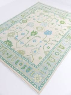 an area rug with green and blue designs on the bottom, in front of a white background