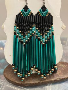 a pair of green and black beaded earrings