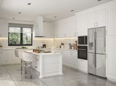 a large kitchen with white cabinets and stainless steel appliances, along with marble flooring