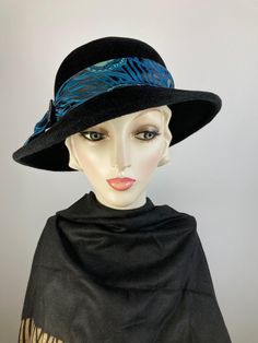 What a classic and classy black wool felt winter hat! This pretty black wool felt hat isn't a true fedora, but it has a similar feel but with a feminine spin. Instead of the top having a point at the front, it has a smooth oval crown. It's hand blocked over wooden hat blocks and hand sewn. The asymmetrical brim is also wider than a traditional fedora.  The band and bow are made with a black, teal and mint green fabric and then topped with a faceted black glass vintage button. This one simply never goes out of style. Handmade in the USA. In stock and ready to ship. One of a kind hat. FIT AND SIZE: Head size: 21 to 23 inches.  Inner adjustable grosgrain ribbon headband. Brim width 2 1/2 inches in the back left side, and 3 inches in the front and right side. HOW TO MEASURE YOUR HEAD SIZE: Pla Brimmed Fur Felt Cloche Hat For Winter, Winter Brimmed Fur Felt Cloche Hat, Winter Brimmed Cloche Hat In Fur Felt, Winter Fur Felt Brimmed Cloche Hat, Winter Fur Felt Cloche Hat With Short Brim, Formal Wool Felt Hat For Winter, Wool Wide Brim Top Hat For Winter, Winter Wool Wide Brim Top Hat, Black Wide Brim Felt Hat For Winter