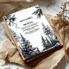 a wedding card on top of a piece of paper next to some dried flowers and leaves