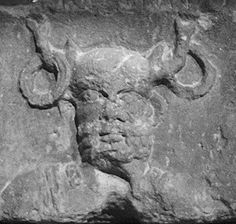 an ancient sculpture with horns on it's head