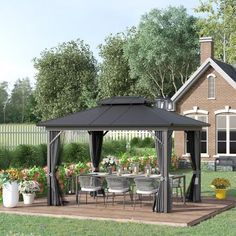 a gazebo sitting on top of a wooden deck next to a lush green field