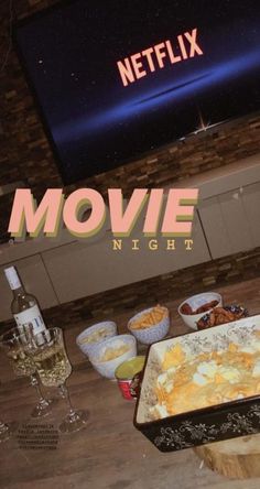 a table topped with food and drinks next to a tv screen that reads movie night