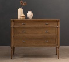 a wooden dresser with two vases on top