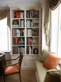 a room with a couch, bookshelf and chair in it's corner