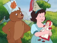 a woman holding a baby in her arms while standing next to a bear