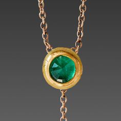 A brilliant rose cut emerald shines within a warm 22k gold wrapping, backed in solid gold, and stationed on a delicate 16 inch, 14k gold chain. The luminous gem is accented with a tiny 22k gold drop that hangs 1 inch below creating a lovely movement. A truly magical piece. Emerald pendant measures approximately 1/4 inch in diameter. Matte finish. This piece will be made to order, and will ship within 10-14 business days. If you need it sooner, use the Notes section on the order form to request a Gold Emerald Necklace With Delicate Chain, Fine Jewelry, Fine Jewelry Gold Emerald Necklace With Delicate Chain, Gold Emerald Necklace With Adjustable Chain, Gold Emerald Pendant Necklace With Bezel Setting, Gold Emerald Necklace With Adjustable Chain For Formal Events, Gold Emerald Necklace With Adjustable Chain For Formal Occasions, Formal Gold Emerald Necklace With Round Pendant, Elegant 22k Gold Emerald Necklace, Emerald Necklace With Delicate Yellow Gold Chain