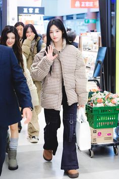 a woman walking down a shopping mall holding her hand up