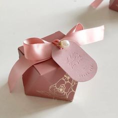 a pink gift box with a ribbon tied around it