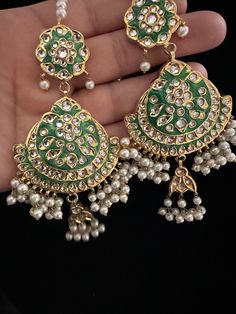 It's time you level up your jewelry box! Add in some extra ordinary piece in your collection! This majestic 22 KT gold plated lock thappa kundan chandbali earrings with beautiful combination of hand painted meena work and kundan pearl work earrings with sahara. In stock and ready to ship. Color : green Note :Color, shades, texture displayed may slightly vary from the actual product due to digital image limitations. We request you to consider these minor variations. Please expect the possibility Kundan Chandbali Jewelry With Tassels, Kundan Chandbali Jewelry With Latkans, Green Kundan Chandelier Earrings With Latkans, Green Stone Work Chandbalis For Celebration, Stone Work Bridal Earrings Gift For Eid, Stone Work Bridal Earrings For Eid, Bridal Earrings With Stone Work For Eid, Bridal Earrings With Stone Work As Gift For Eid, Gold Chandbali Earrings With Mirror Work