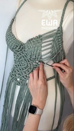 a woman is working on a piece of clothing that has been made with yarn and crochet