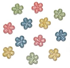 six different colored flower shaped buttons on a white background