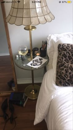 a bedroom with a lamp, phone and other items on the table next to it