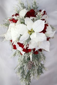 a bouquet of white and red flowers with pine cones