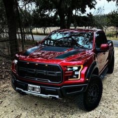 a red truck is parked in the dirt