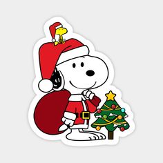 a snoopy christmas sticker with a santa hat on and a tree in the foreground