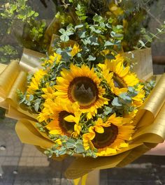 a bouquet of sunflowers is wrapped in yellow ribbon