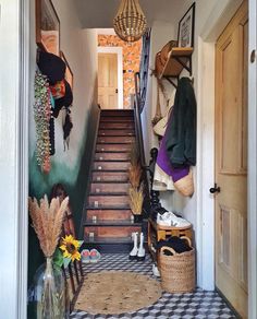 an entry way leading up to a hallway with lots of clothes hanging on the wall